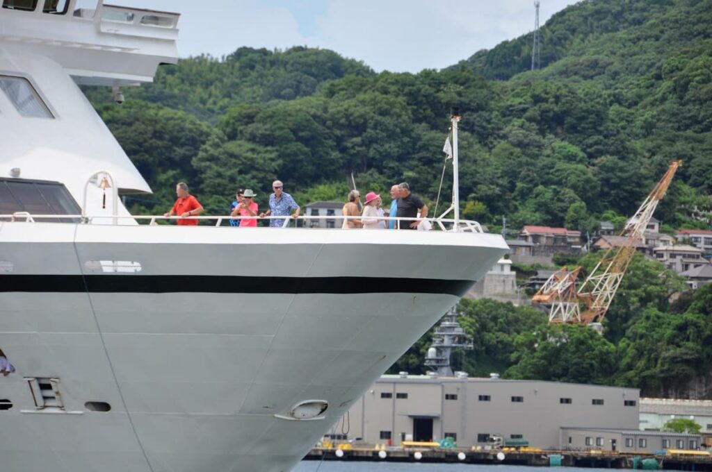 長崎の景色を船首で楽しむ乗客の方々